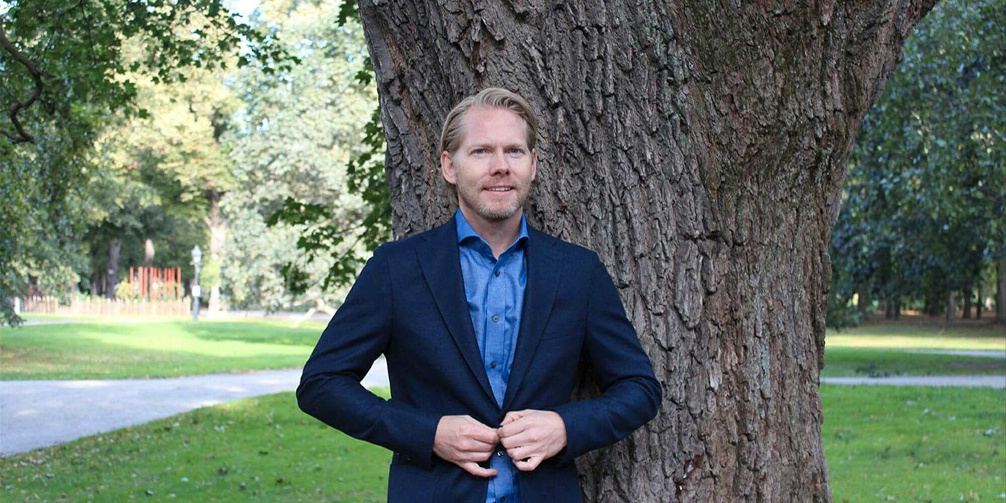 Michael Hansen står vid ett träd 